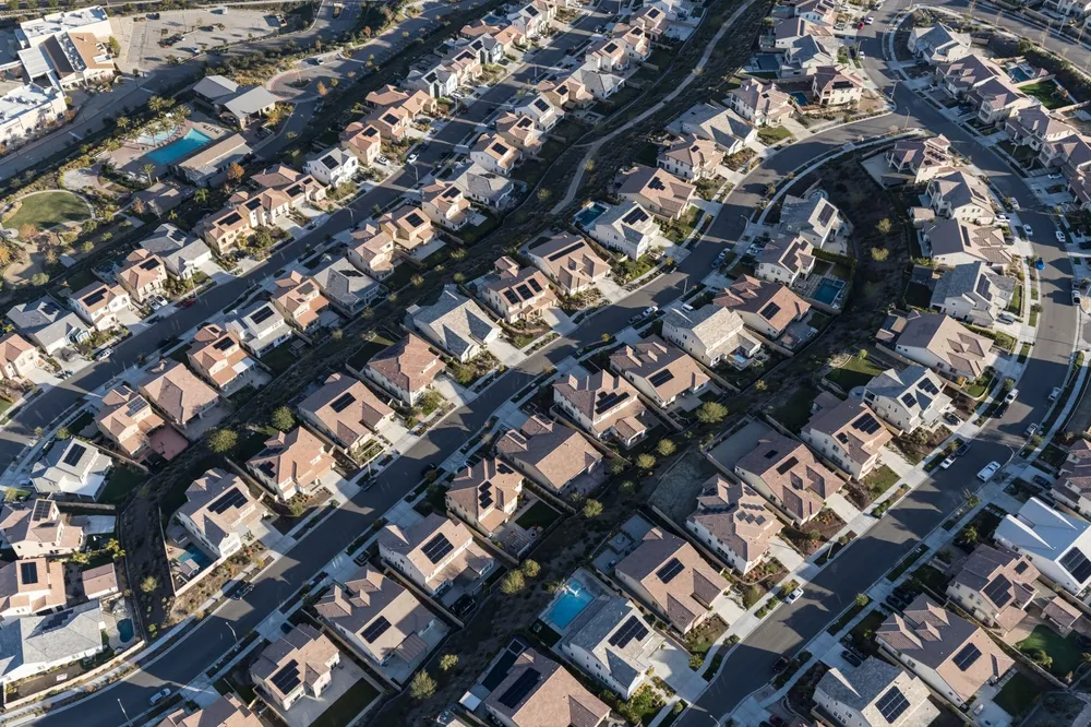 Aerial view of suburban neighborhood with solar installations